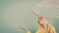 Woman wearing raincoat holding umbrella checking weather