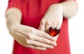 Woman wearing a red dress shows a ring with a huge ruby colored heart-shaped plastic gem. Selective focus Royalty Free Stock Photo