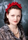 Woman wearing red felt adornment in retro stlyle looking incr