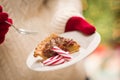 Woman Wearing Red Mittens Holding Plate of Pecan Pie with Peppermint Candy Against Decorated Tree and Lights Royalty Free Stock Photo