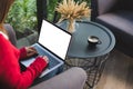 woman wearing red sweater typing on computer at home. female adult sitting on armchair using laptop at cafe. education, working c Royalty Free Stock Photo