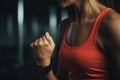 A woman wearing a red tank top showcases her black watch while holding it in her hand, Close-up of a heart rate monitor on a wrist Royalty Free Stock Photo