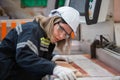 woman wearing safety uniform and hard hat working quality inspection of wood products at workshop manufacturing wooden. female Royalty Free Stock Photo