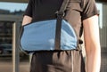 Woman wearing sling to support painful arm. Pain caused by overuse, injury, chronic diseases. Female recovering from Royalty Free Stock Photo