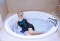 Woman wearing slip dress relaxing in the bath