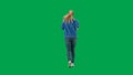 A woman wearing sneakers, blue jeans and a hoodie, running on a green screen. Back view of a full length woman jogging Royalty Free Stock Photo