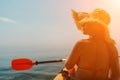 A woman wearing a straw hat is paddling a canoe on a sunny day. Scene is relaxed and carefree, as the woman enjoys her Royalty Free Stock Photo