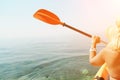 A woman wearing a straw hat is paddling a canoe on a sunny day. Scene is relaxed and carefree, as the woman enjoys her Royalty Free Stock Photo