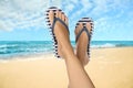 Woman wearing stylish flip flops resting on sandy beach and enjoying beautiful seascape, closeup