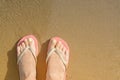 Woman wearing stylish flip flops on sandy beach, top view. Space for text Royalty Free Stock Photo