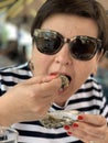 Woman Eating A Fresh Oyster On The Half Shell In Food Court Of A Seafood Market In Trouville, France