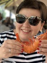 Woman Smiling With Huge Langoustine In Food Court Of A Seafood Market In Trouville, France