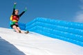 Woman Wearing Superhero Costume Goes Down Obstacle Race Slide