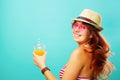 Woman wearing swimsuit and hat drinks fruit juice from a cup Royalty Free Stock Photo