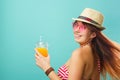 Woman wearing swimsuit and hat drinks fruit juice from a cup Royalty Free Stock Photo