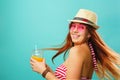 Woman wearing swimsuit and hat drinks fruit juice from a cup Royalty Free Stock Photo