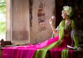 woman wearing Thai traditional dress hand holding lotus fl