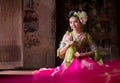 Woman wearing Thai traditional dress hand holding lotus fl