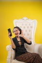 woman wearing traditional Javanese clothes making a video call