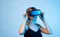 Woman using virtual reality headset in studio with blue light, immersive technology and futuristic digital interaction Royalty Free Stock Photo