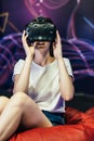 Woman wearing VR goggles. She is fascinated about what she sees