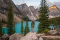 Woman wearing warm clothes standing in front of the Moraine Lake in Alberta, Canada during daylight