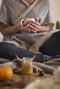 Woman wearing warm cosy clothes drinking mug of hot chocolate in autumn