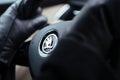 Woman wearing warm mittens gloves while holding the steering wheel of a luxury Skoda electric hybrid SUV limousine car