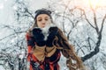 Woman Wearing Warm Winter Clothes And Hat Blowing Snow In Winter Park. Flying Snowflakes. Sunny day. Joyful Beauty young Royalty Free Stock Photo