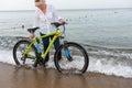 Woman standing in the surf with her bicycle Royalty Free Stock Photo