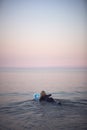 Woman Wearing Wetsuit Paddling Floating Surfboard Out Onto Calm  Sea Royalty Free Stock Photo