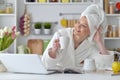 Woman wearing a white bathrobe with laptop Royalty Free Stock Photo