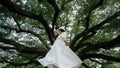 Woman wearing white dress enjoying good moment an standing under the Giant Monkey Pod trees in Kanchanaburi, Thailand