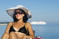 Woman wearing a white straw hat looking at the sea