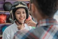 Woman wears a helmet with the help of a shop assistant when attaching the strap buckle