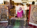 Woman weave carpet in window of shop in Istanbul