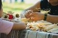 A woman weaves from corn leaves. Demonstration of art to a child