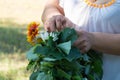 Woman weaves a wreath of linden branches and flowers