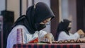 A woman is weaving cloth, or so-called traditional tapis cloth