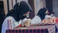 A woman is weaving cloth, or so-called traditional tapis cloth