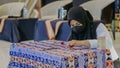 A woman is weaving cloth, or so-called traditional tapis cloth