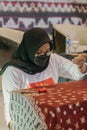 A woman is weaving cloth, or so-called traditional tapis cloth