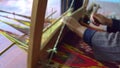 Woman weaving a fabric with on traditional pedal loom