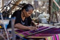 A woman is weaving traditional colorful fabrics of Flores. All weaving processes use manual and traditional equipment