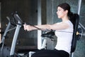 Woman weight training at gym. Exercising on pull down weight machine. Woman doing pull-ups exercising lifting dumbbells. Royalty Free Stock Photo