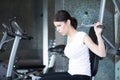 Woman weight training at gym.Exercising on pull down weight machine.Woman doing pull-ups exercising lifting dumbbells.