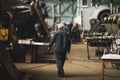 Woman welder in a dirty and old but still functioning metal works, old fashioned, factory