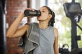 Woman, wellness and water bottle in gym, exercise and body health for break with towel for workout. Liquid, energy and Royalty Free Stock Photo