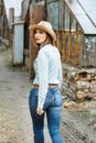 Woman in western wear in cowboy hat, jeans and cowboy boots. Royalty Free Stock Photo