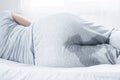 Woman with wet pants because of Stress urinary incontinence can`t control her pee while sleeping in bed Royalty Free Stock Photo